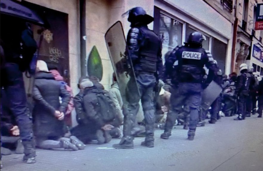 manifestants à genoux, les mains dans le dos